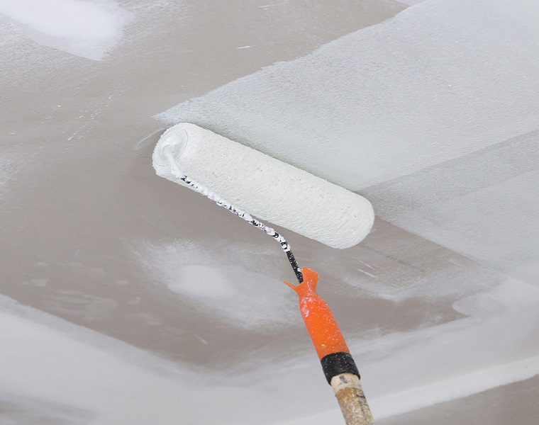 Applying emulsion paint on ceiling